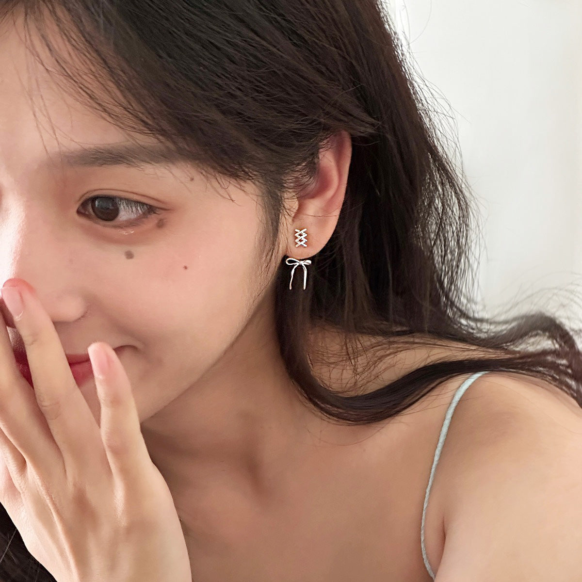 Model showcasing the delicate 925 sterling silver bowknot stud earrings