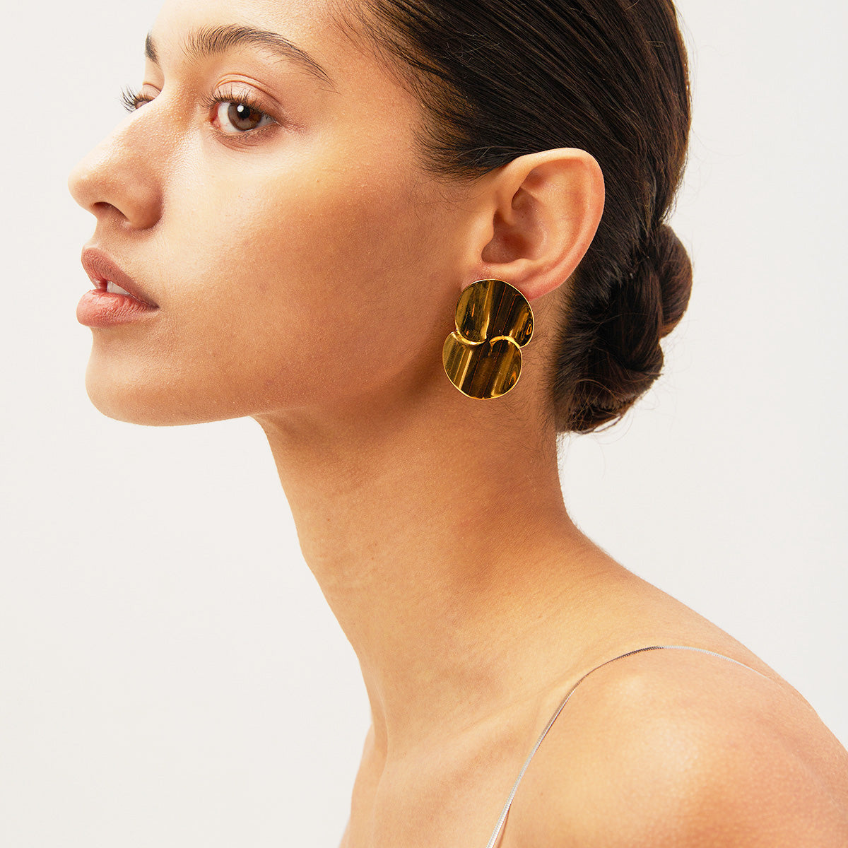Model wearing the chunky gold disc drop earrings to show scale.