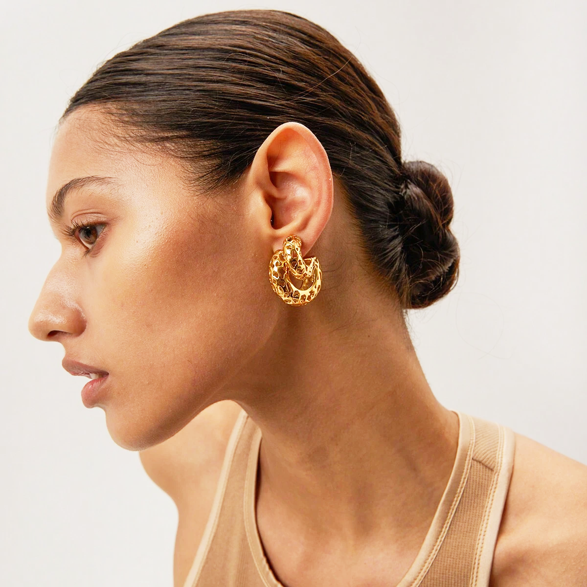 Model showcasing the elegant fit of the gold C-shaped earrings