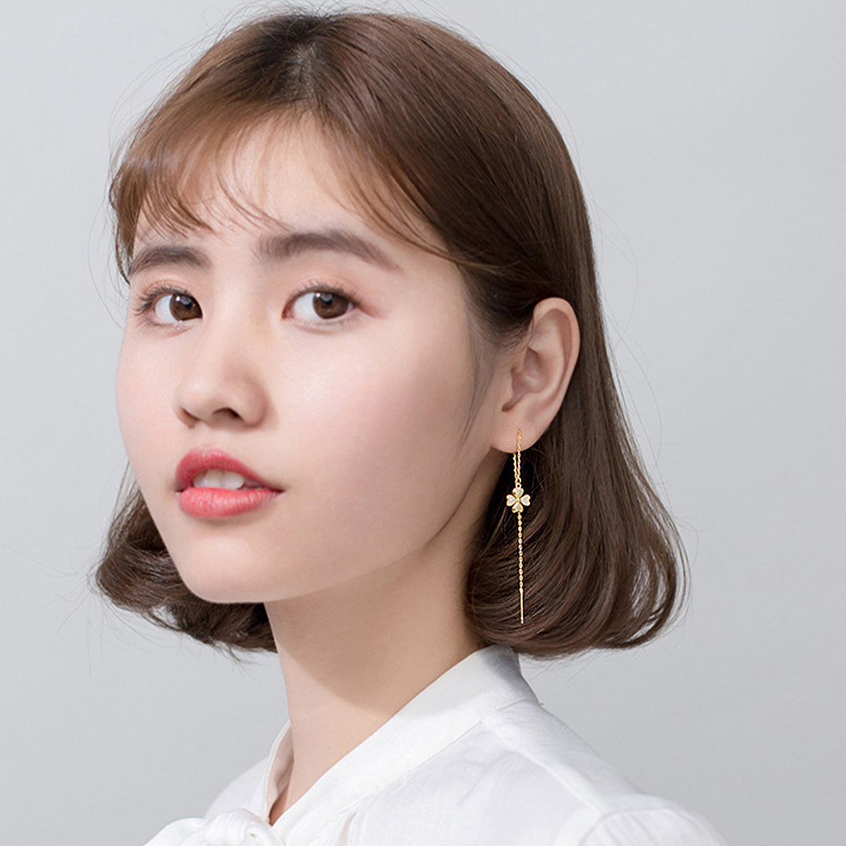 Model wearing the Gold Four Leaf Clover Dangle Chain Earrings