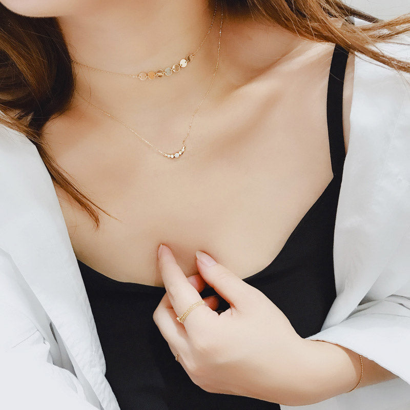 Model showcasing the elegant 18k gold smile disc clavicle necklace