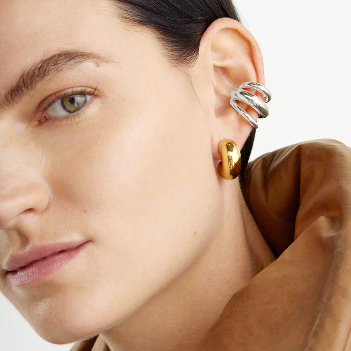 A model showcasing the stylish fit of the silver three-layer ear cuff