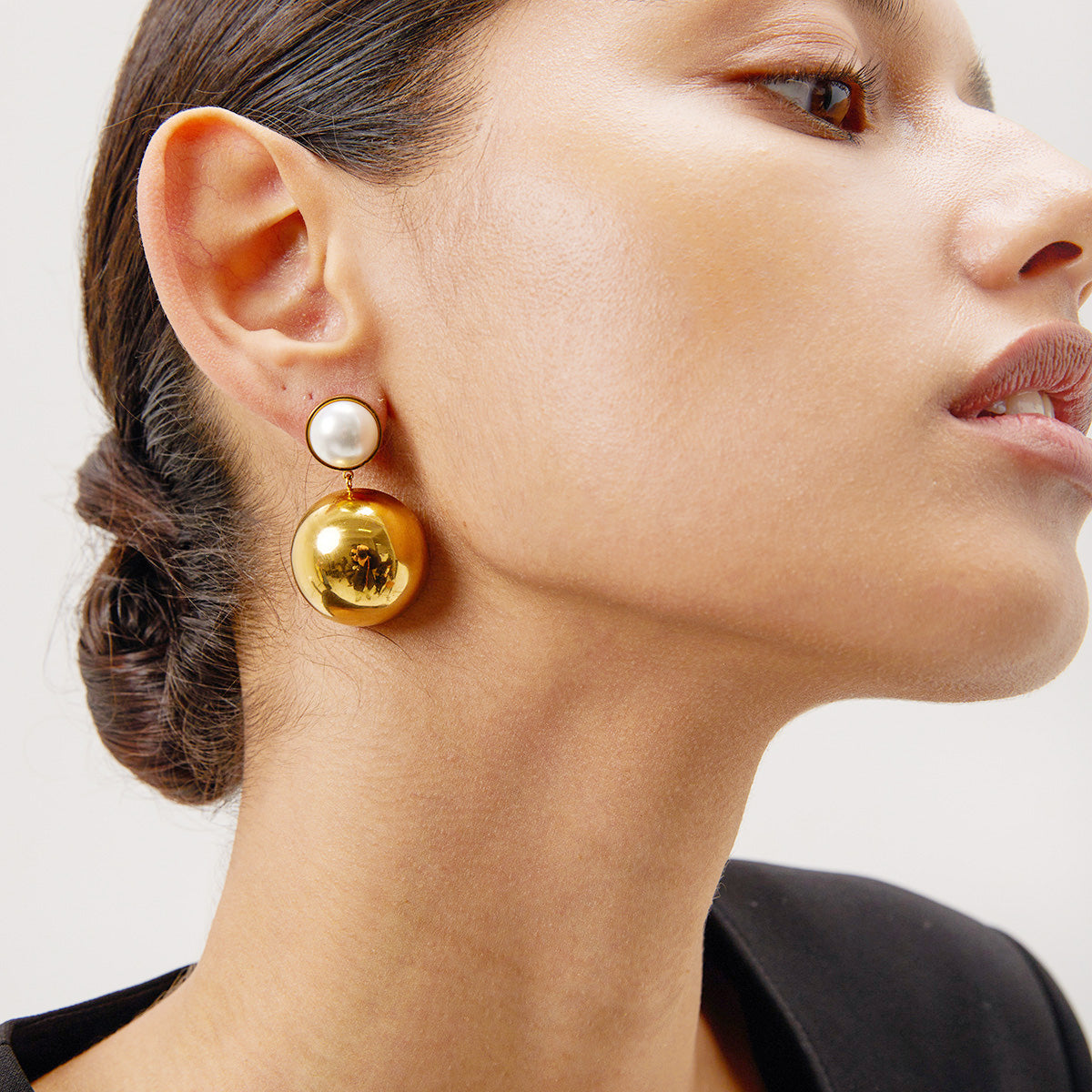 Model wearing the stainless steel gold inlaid pearl dome drop earring