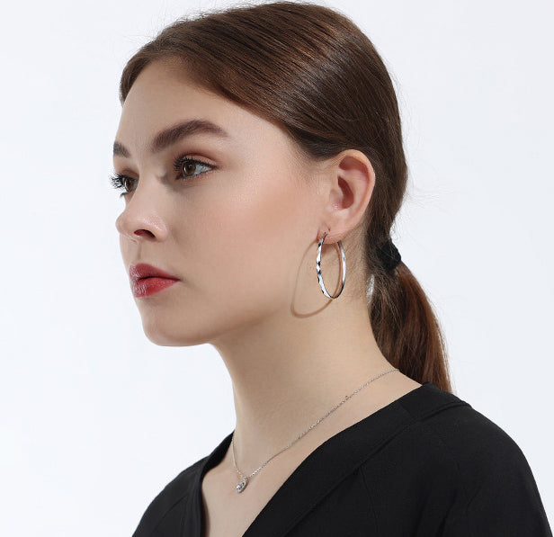 Model wearing the 42mm sterling silver diamond-texture hoop earrings