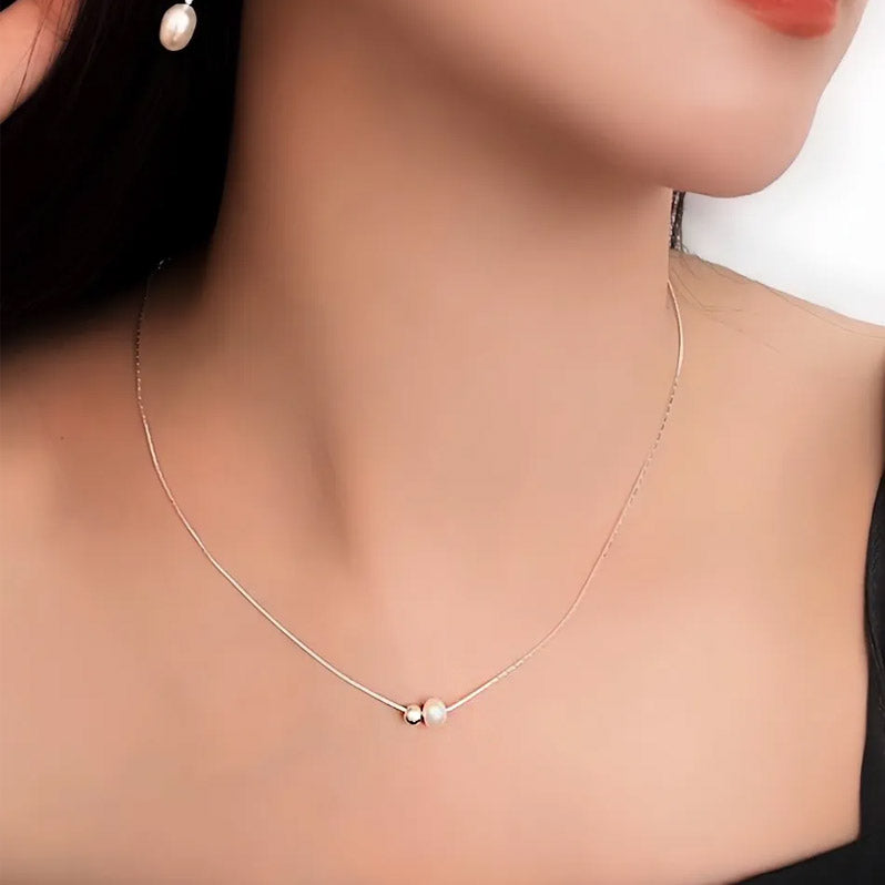 A woman elegantly wearing the sterling silver pearl snake chain necklace.