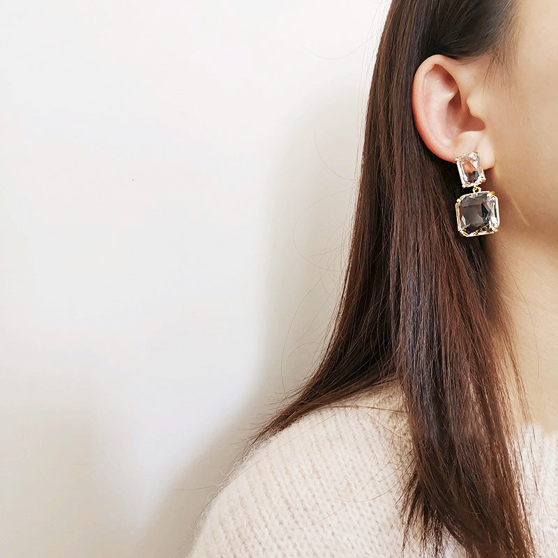 A woman wearing the geometric square transparent crystal drop earring, highlighting its chic appearance.