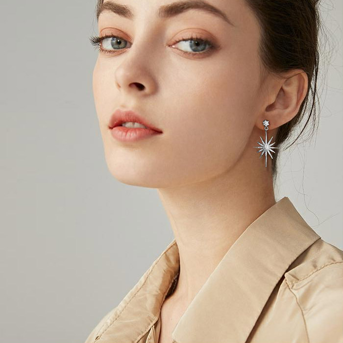 A woman elegantly wearing the Latelita Rhodium Star Bridal Earrings