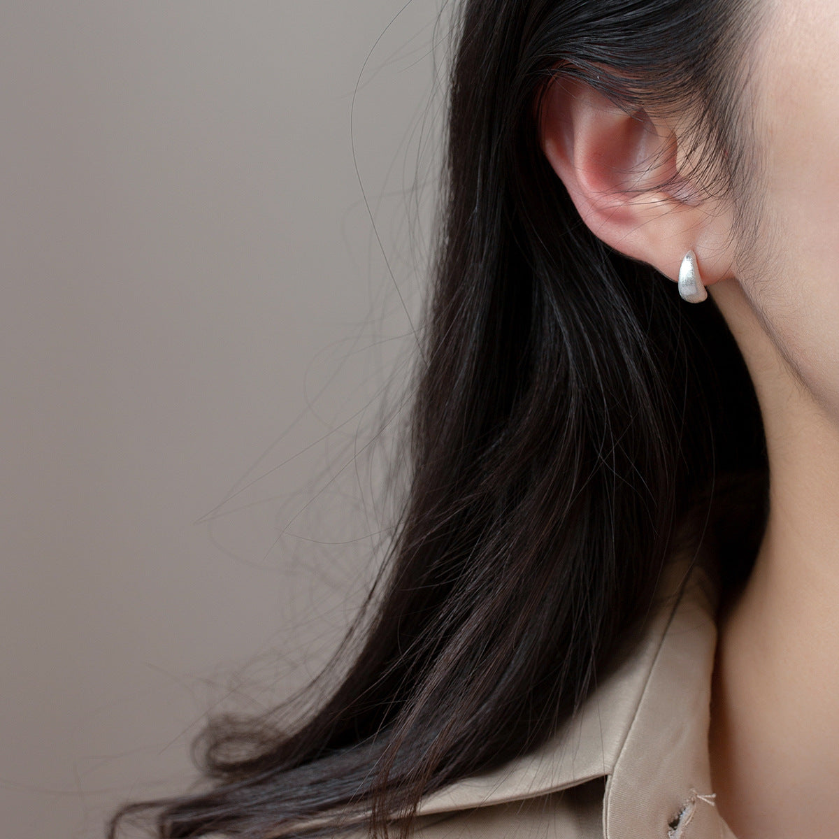 Model showcasing the elegant fit of the 925 silver frosted curl stud earrings