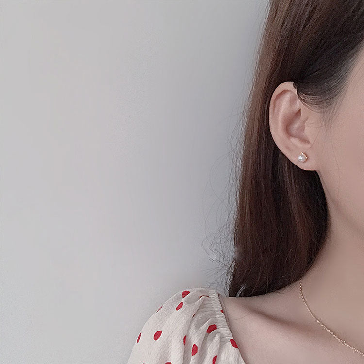 Model showcasing the elegant single pearl stud earrings