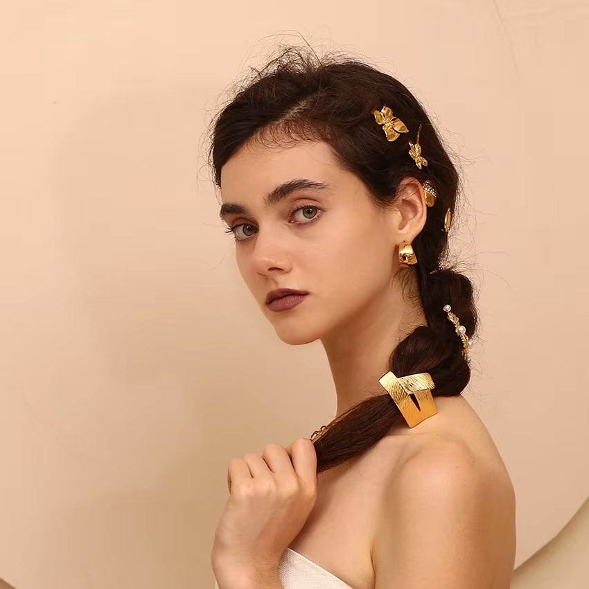 Model wearing the gold geometric hair tie, showcasing its elegant style.