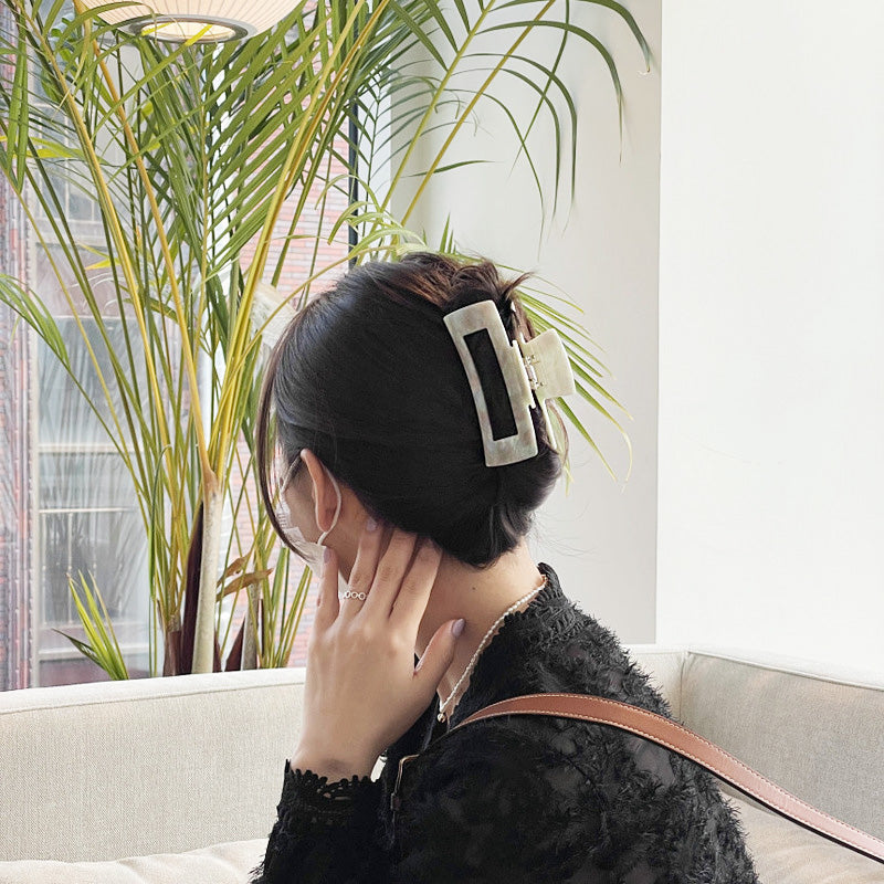 A woman with a white marbled hair clip.