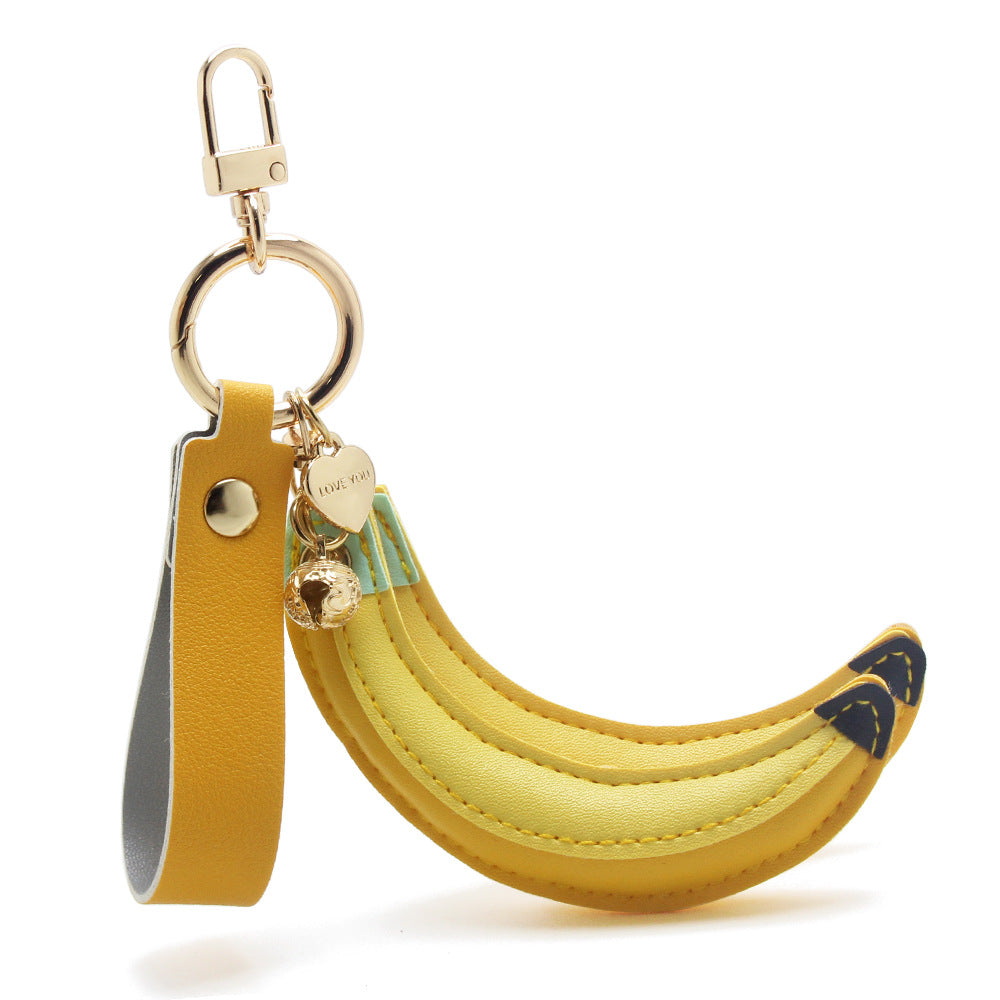 A detailed view of the single banana PU leather keychain with its sturdy gold clip and charm.