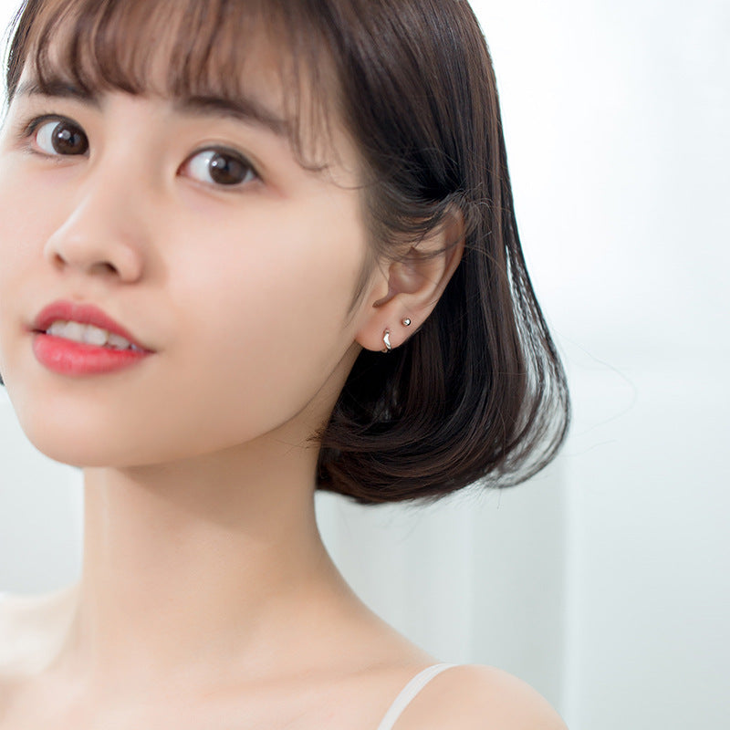 Model showcasing the Sterling Silver V-Shape Huggie Earrings