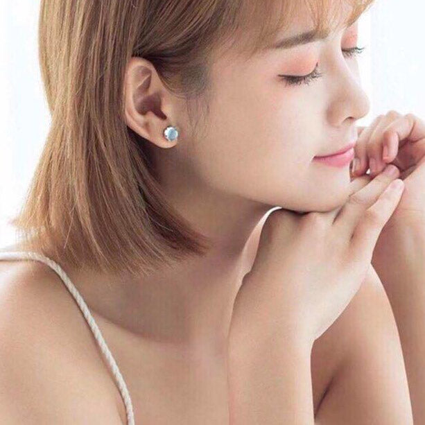 Model showcasing the asymmetrical moonstone mermaid earring for a subtle yet elegant look.