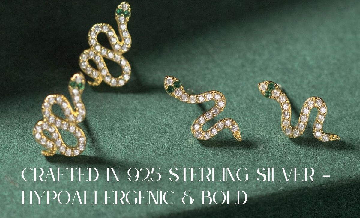 Gold snake stud earrings with CZ stones, crafted in 925 sterling silver and displayed on green velvet background
