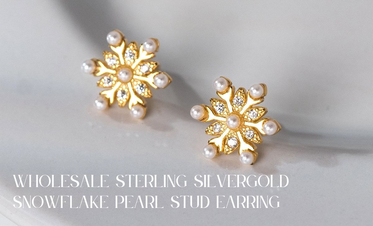  Close-up of dainty 925 silver gold snowflake pearl earrings with CZ stones, perfect for snowflake earrings studs and jewelry made of silver.