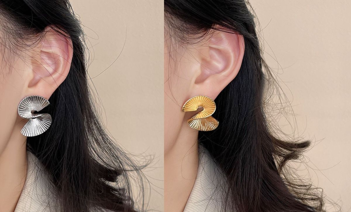 Model wearing geometric statement earrings in irregular hoop design, 14K gold plated earrings and silver finish, trendy wholesale jewelry for women.