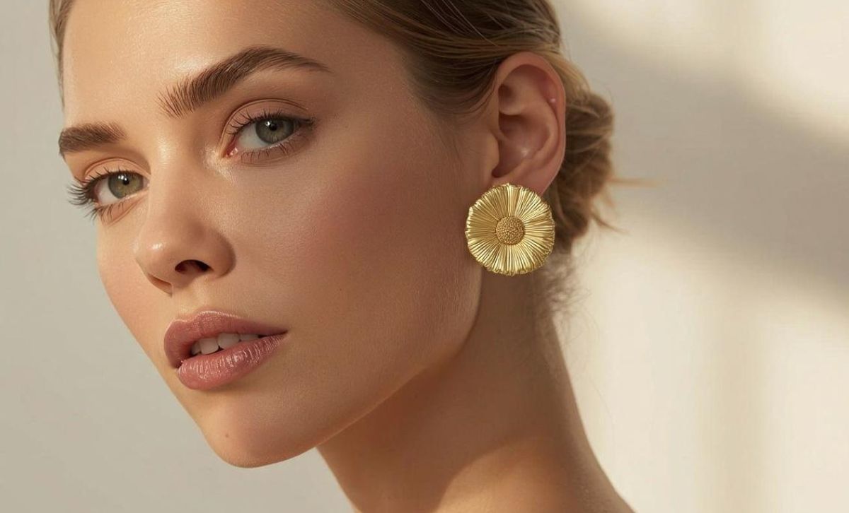 Model wearing large nickel-free gold flower earrings designed for sensitive skin by JR Fashion Accessories.